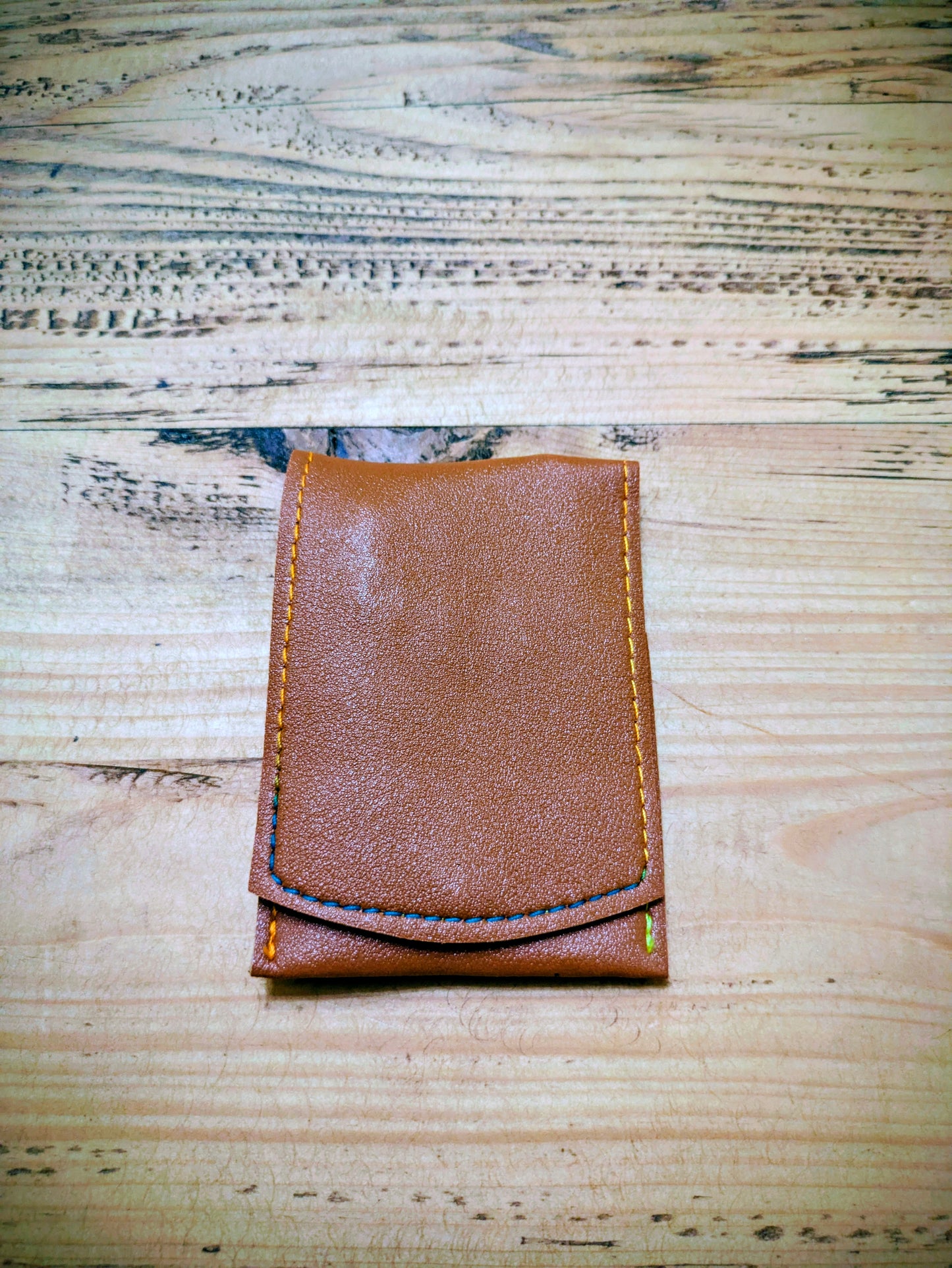 Folded brown leather grooming kit with visible stitching, compact and ideal for travel or gifting.