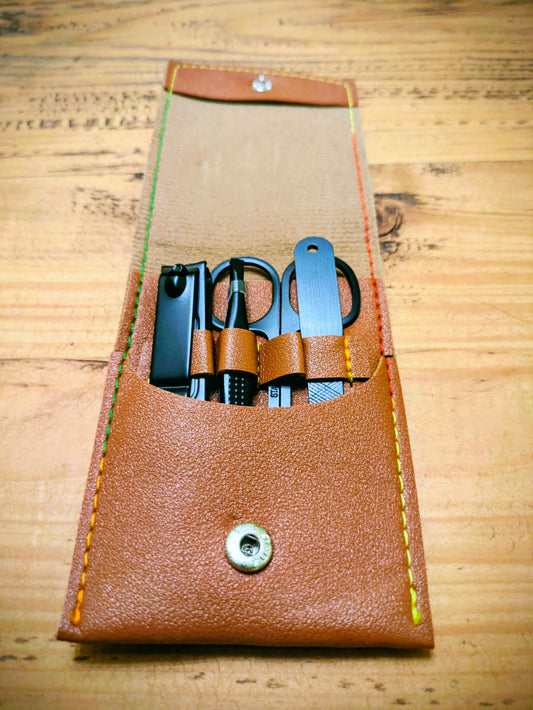 Personalised leather grooming kit for travel with compact manicure tools neatly stored in a brown leather case with multicolour stitching.