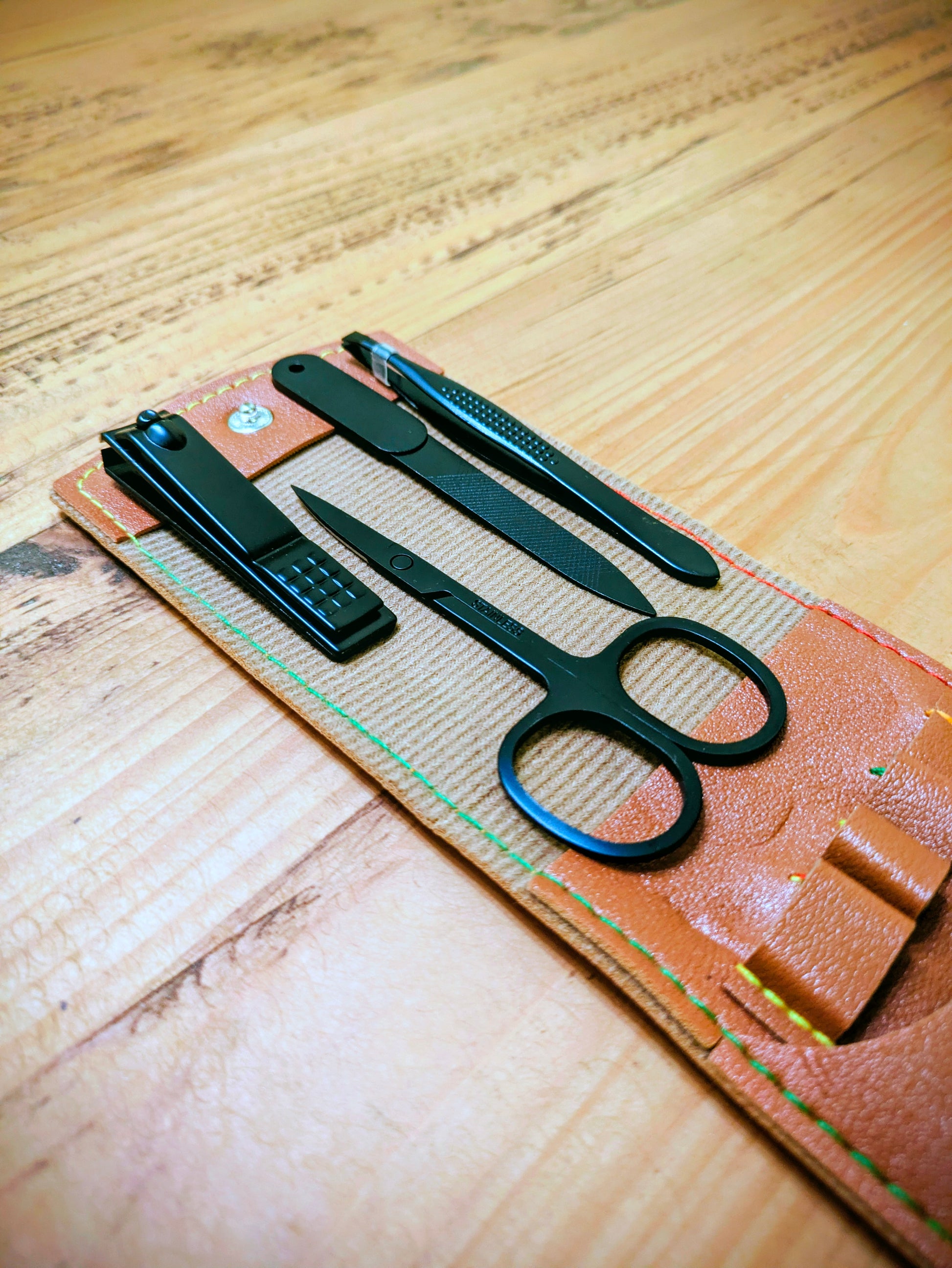 Flat lay of compact grooming tools displayed on open brown leather case, ideal for travel and personal care organisation.